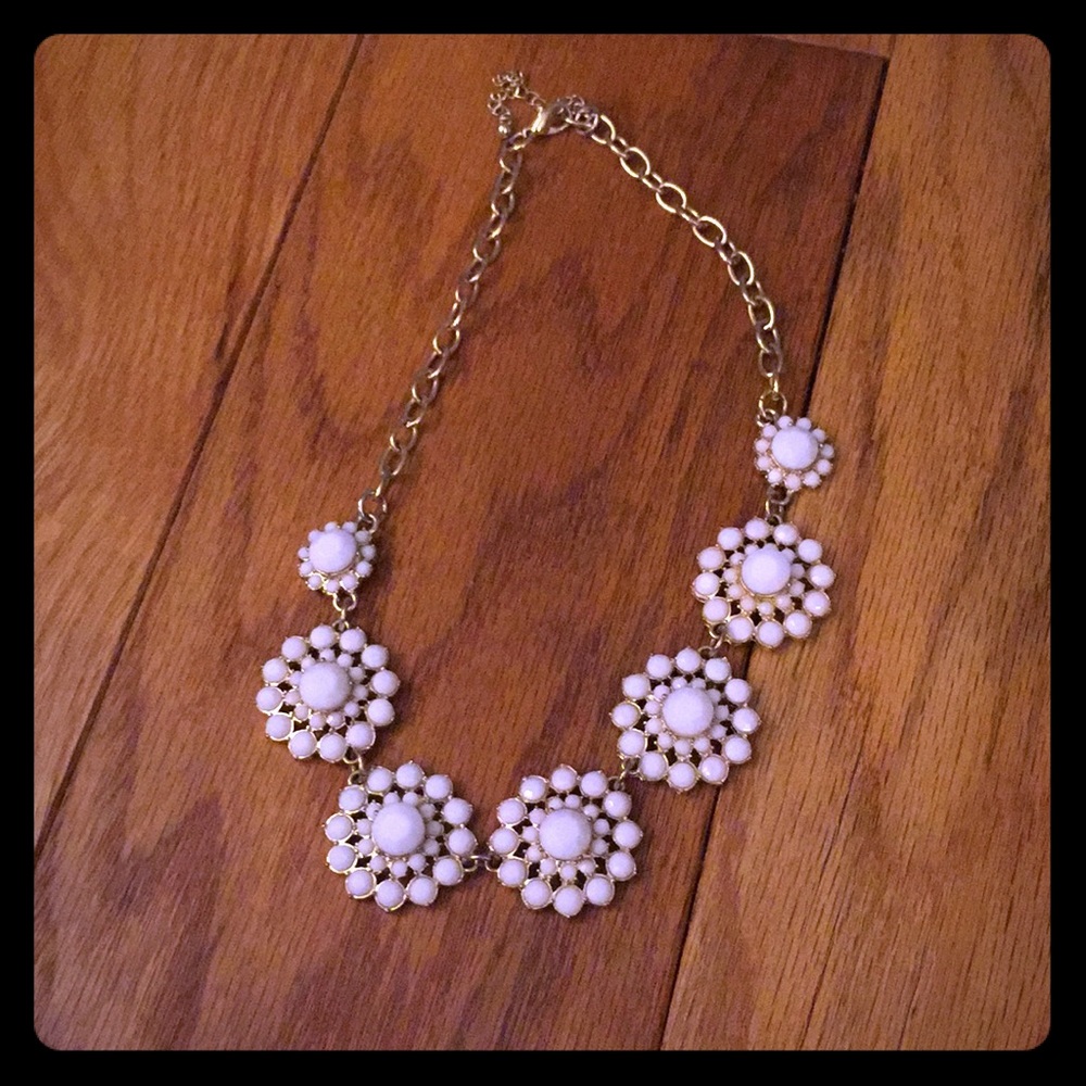 A white and gold flowery necklace.